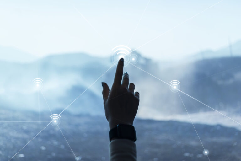 technology - An abstract background image featuring digital communication technology. A person's hand is shown reaching towards the image, as if to touch it. The background is composed of various digital elements, such as circuits, dots, and lines, in shades of blue and purple. The hand is in focus, while the background is out of focus and appears blurred.